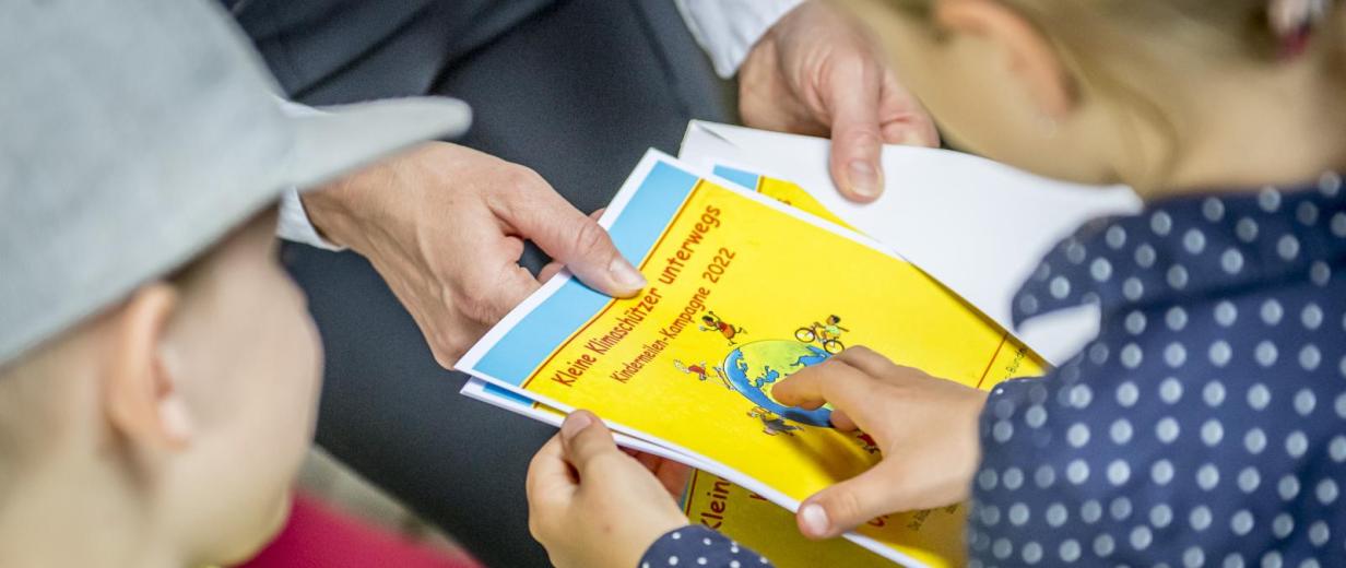 Kindermeilen Zwei Personen schauen auf einen Flyer.