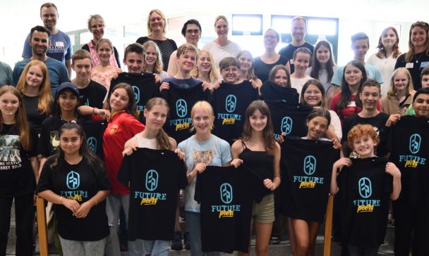 Eine Personengruppe steht in einem Foyer auf einer Treppe