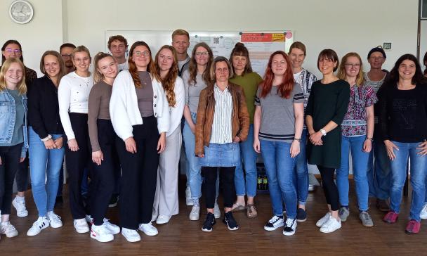 Eine Personengruppe steht in einem Gebäudeflur.