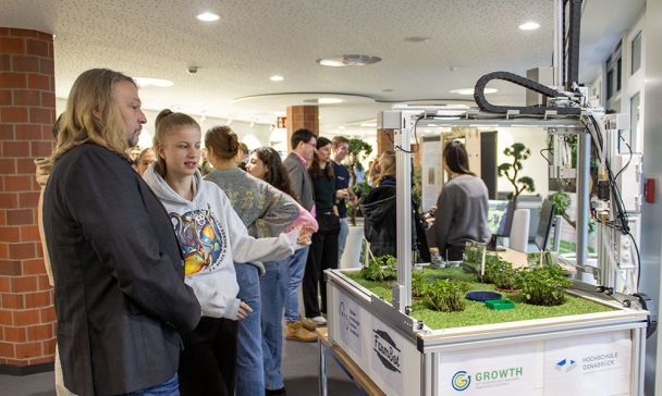 Personen präsentieren ihre Forschungsergebnisse in einem Foyer.