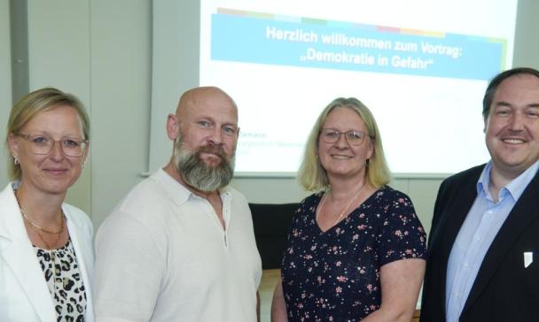 Vier Personen schauen in die Kamera.